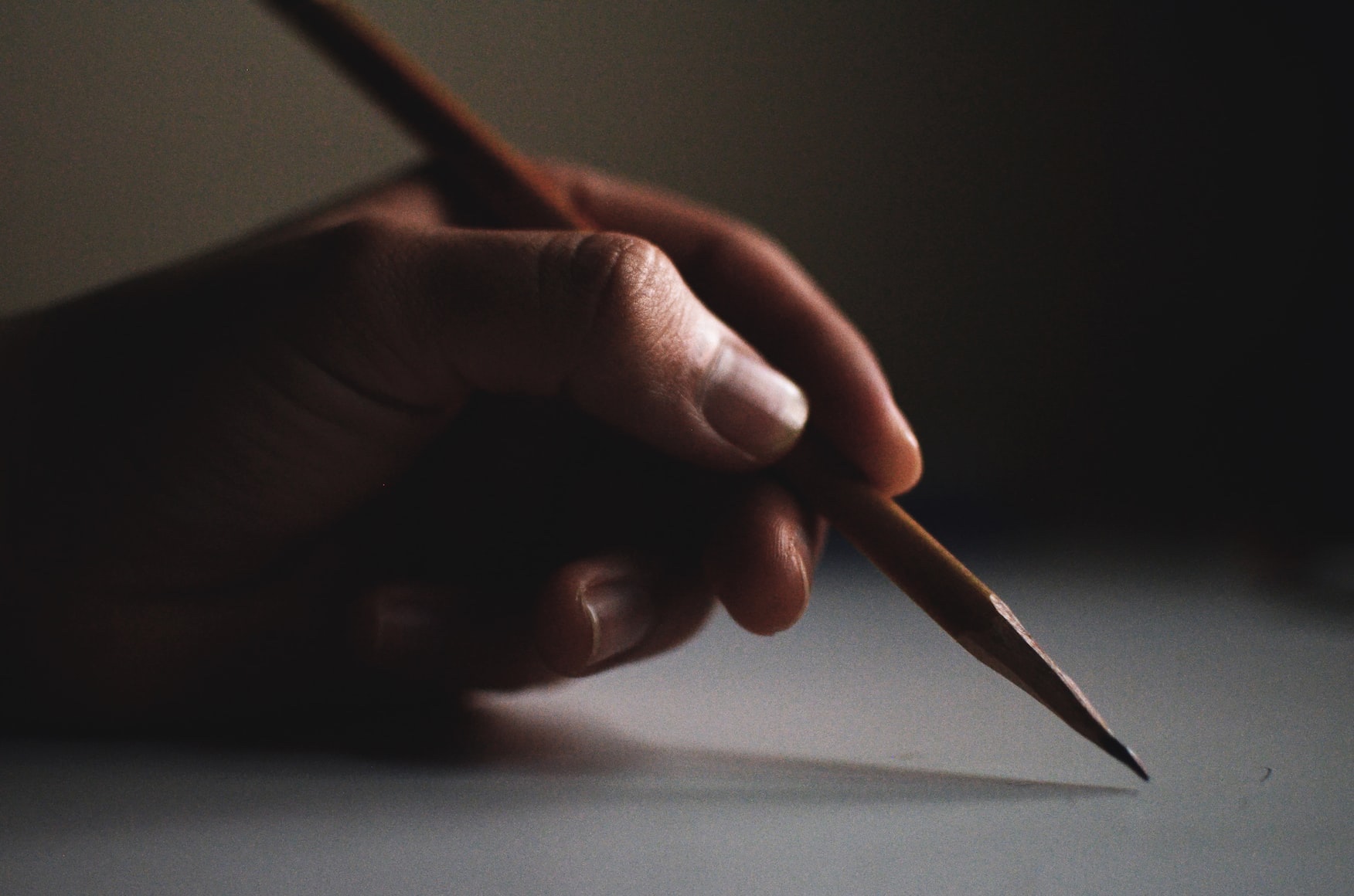 Hand holding a pencil poised for writing
