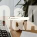 A stylized graphic with the text "Ask Anything" overlaying a peaceful desk scene with a calculator and iced coffee.