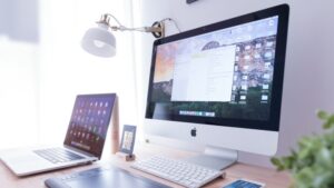 Modern workspace with an iMac, laptop, tablet, smartphone, and drawing tablet on a desk, under a lamp.